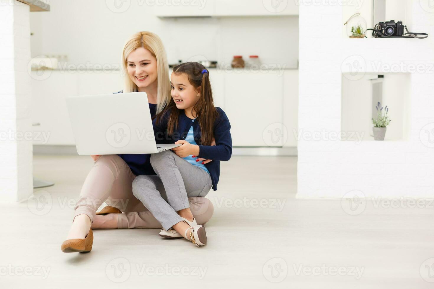 mooi vrouw helpen haar dochter aan het doen haar huiswerk in een keuken foto