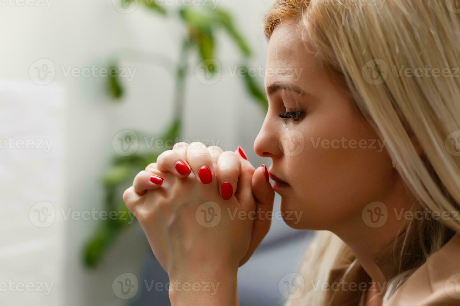 detailopname portret van een jong Kaukasisch vrouw bidden, tegen abstract groen achtergrond foto