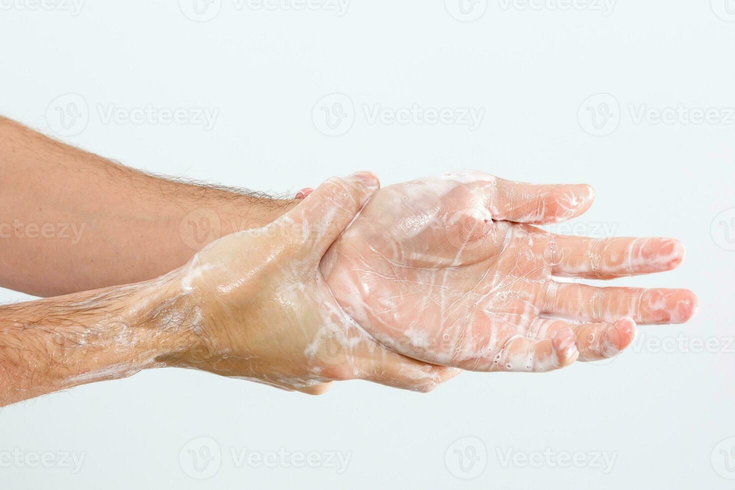 dichtbij omhoog beeld van het wassen hand- tegen wit achtergrond foto