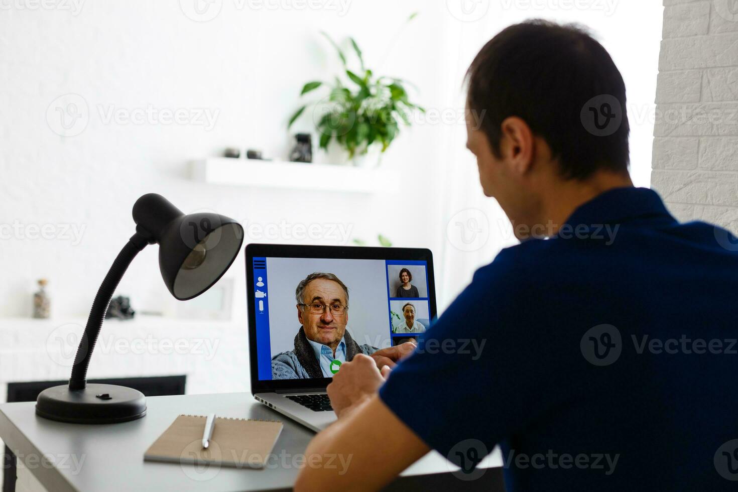 gelukkig jong Mens in t-shirt zittend Bij huis, werken Aan laptop computer, lachend. foto