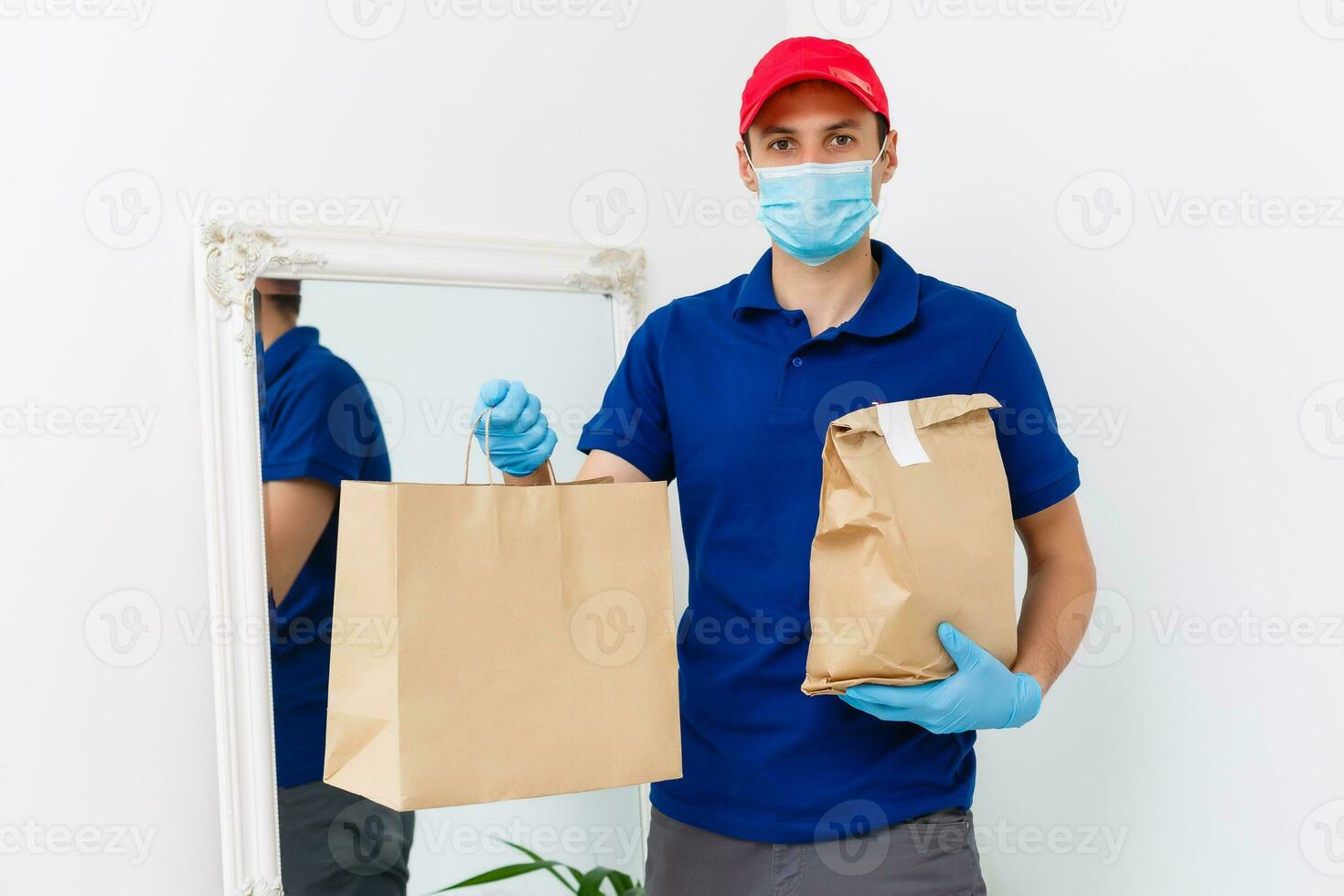 voedsel levering Mens in beschermend masker foto