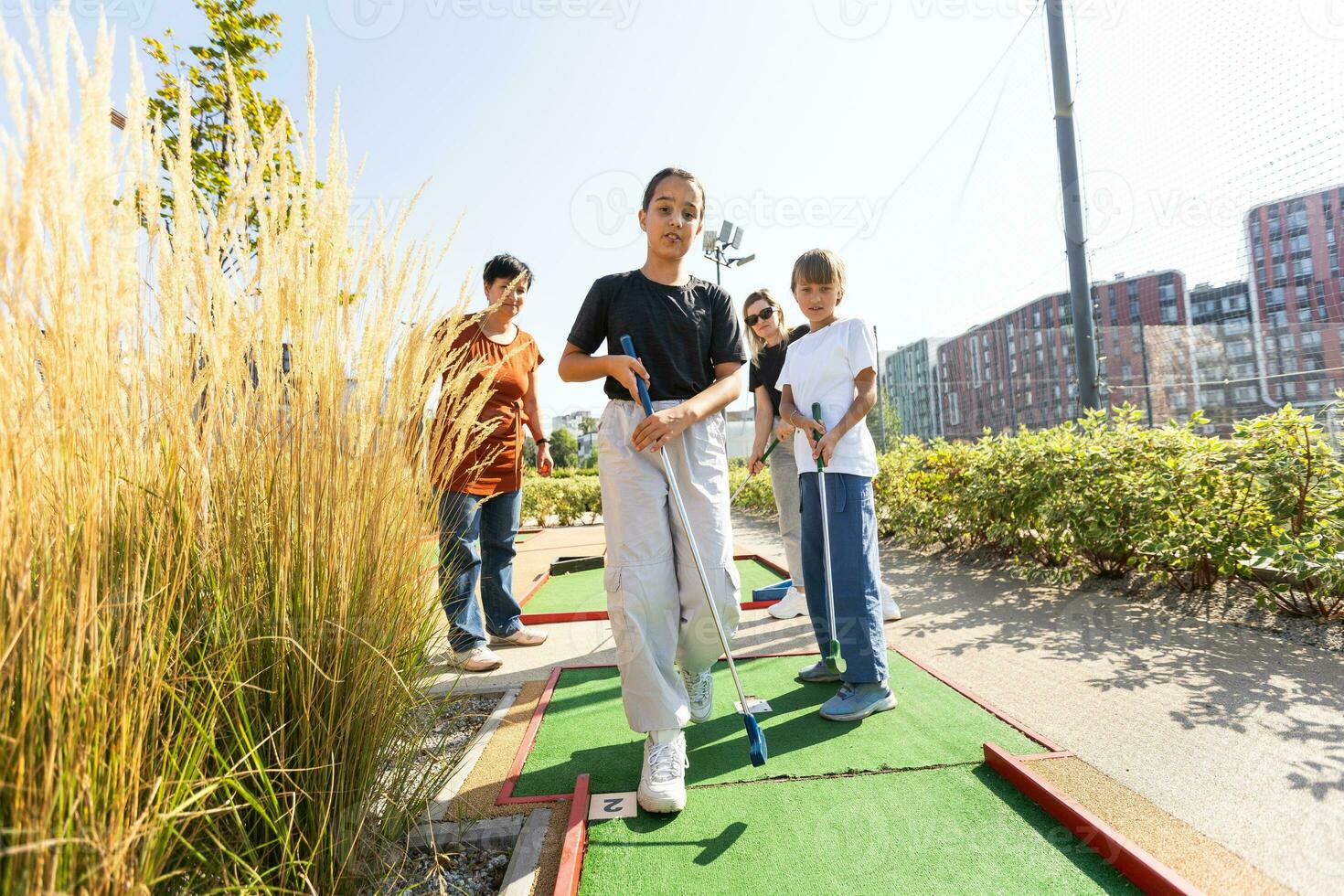 familie spelen mini golf Aan een reis voering. kind hebben pret met actief vrije tijd Aan vakanties. foto