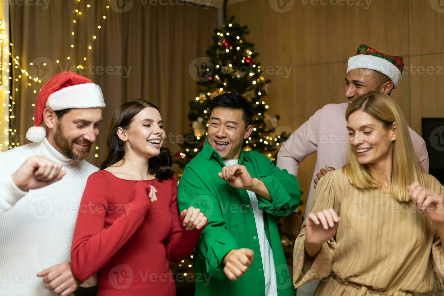 nieuw jaar feest. pret en gelukkig bedrijf van interraciaal jong mooi mensen, jongens en meisjes. wie dans in de huis in de buurt de Kerstmis boom. foto