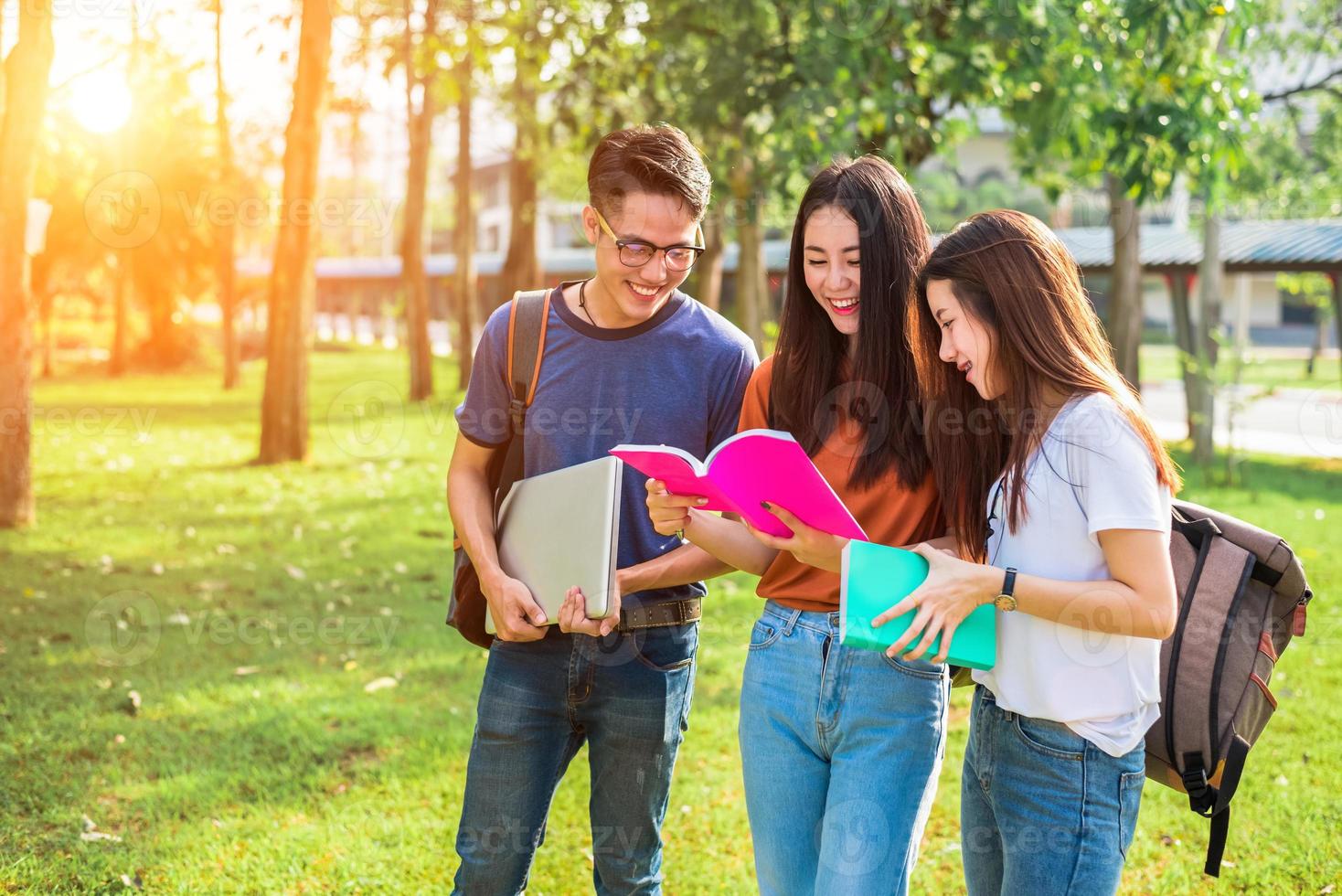 drie aziatische jonge campusmensen die bijles geven en zich voorbereiden op het eindexamen aan de universiteit. onderwijs en leren concept. vriendschap en relatie schip concept. thema college en buitenlucht foto