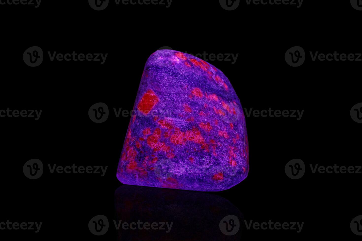 macro mineraal steen robijn onder ultraviolet licht Aan een zwart achtergrond foto