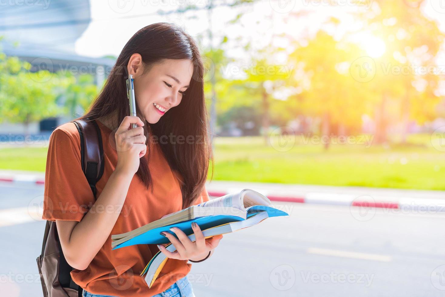 Aziatische jonge universiteitsvrouw die huiswerk doet en boeken leest voor het eindexamen op de campus. universiteit en studentenconcept. levensstijl en schoonheidsconcept. thema tiener en leren foto