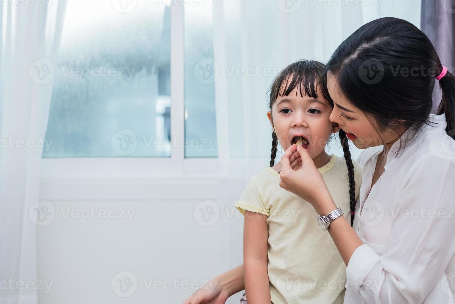 moeder voedt kinderen met chips. leraar die student voedt met een snack. terug naar school en onderwijsconcept. kinderen en kinderen thema. home sweet home en kinderkamer thema foto