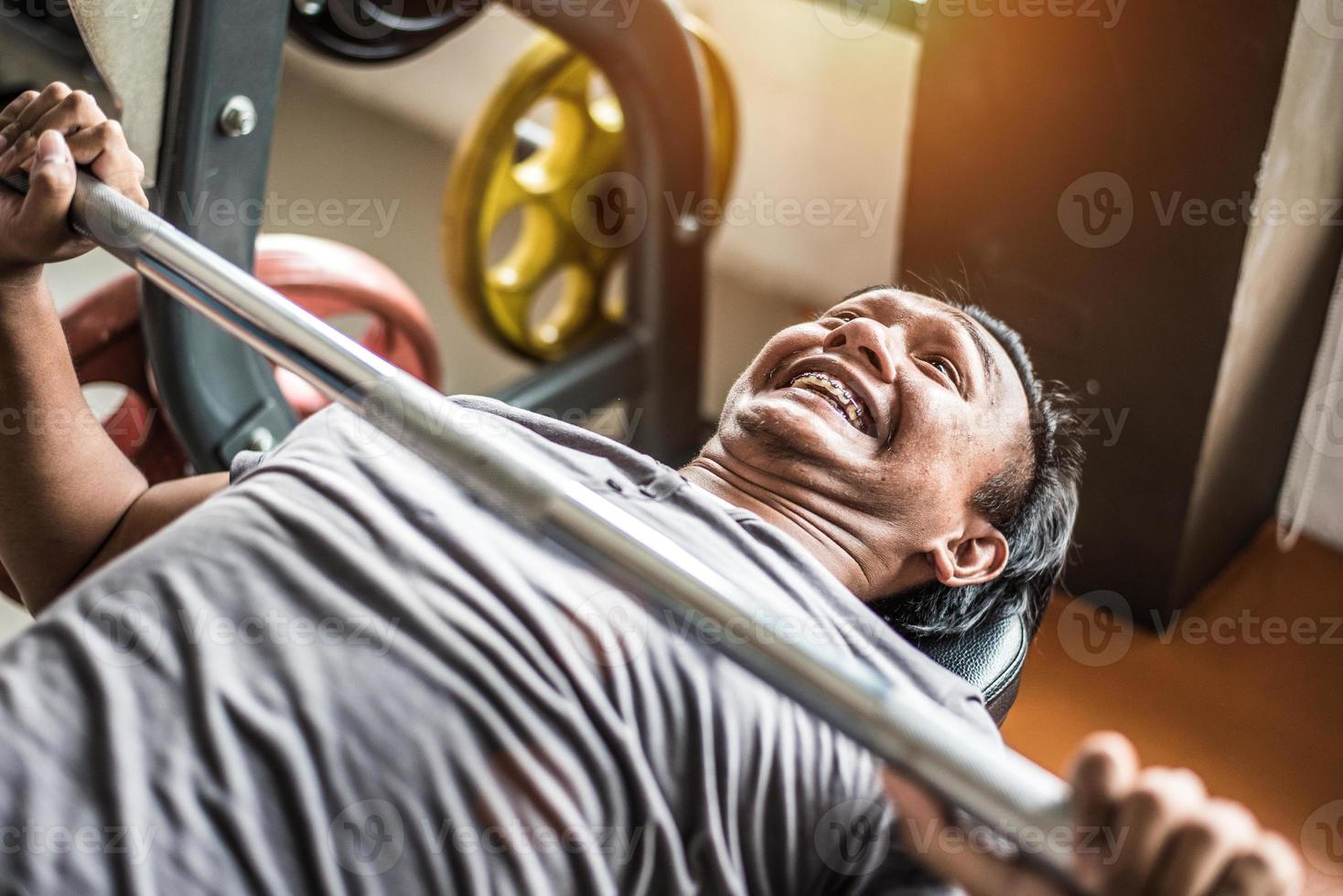 Aziatische jonge man doet Gewichtheffen met barbell in fitness gym sportclub. sport en lichaamsopbouw concept. kracht en gespierd trainingsconcept. grappig en inspanning thema foto
