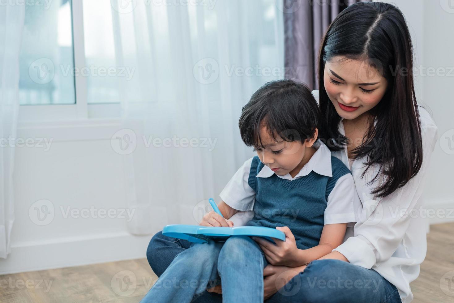 Aziatische moeder leert schattige jongen samen tekenen in schoolbord. terug naar school en onderwijsconcept. familie en home sweet home thema. thema voor kleuters foto