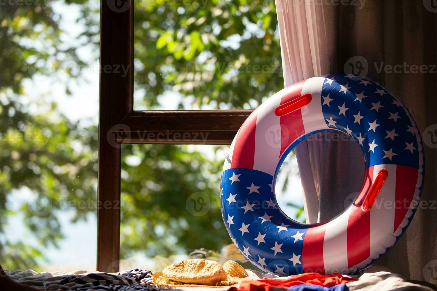 opblaasbaar zwemmen ring met Amerikaans vlag afdrukken Aan venster achtergrond. strand vakantie in Amerika. foto