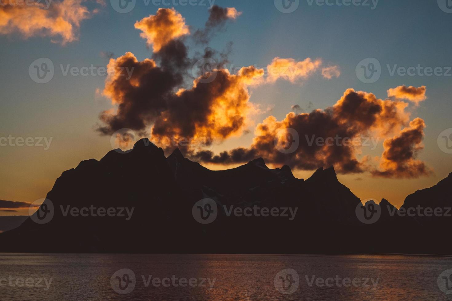 zonsondergang over de bergen aan zee foto