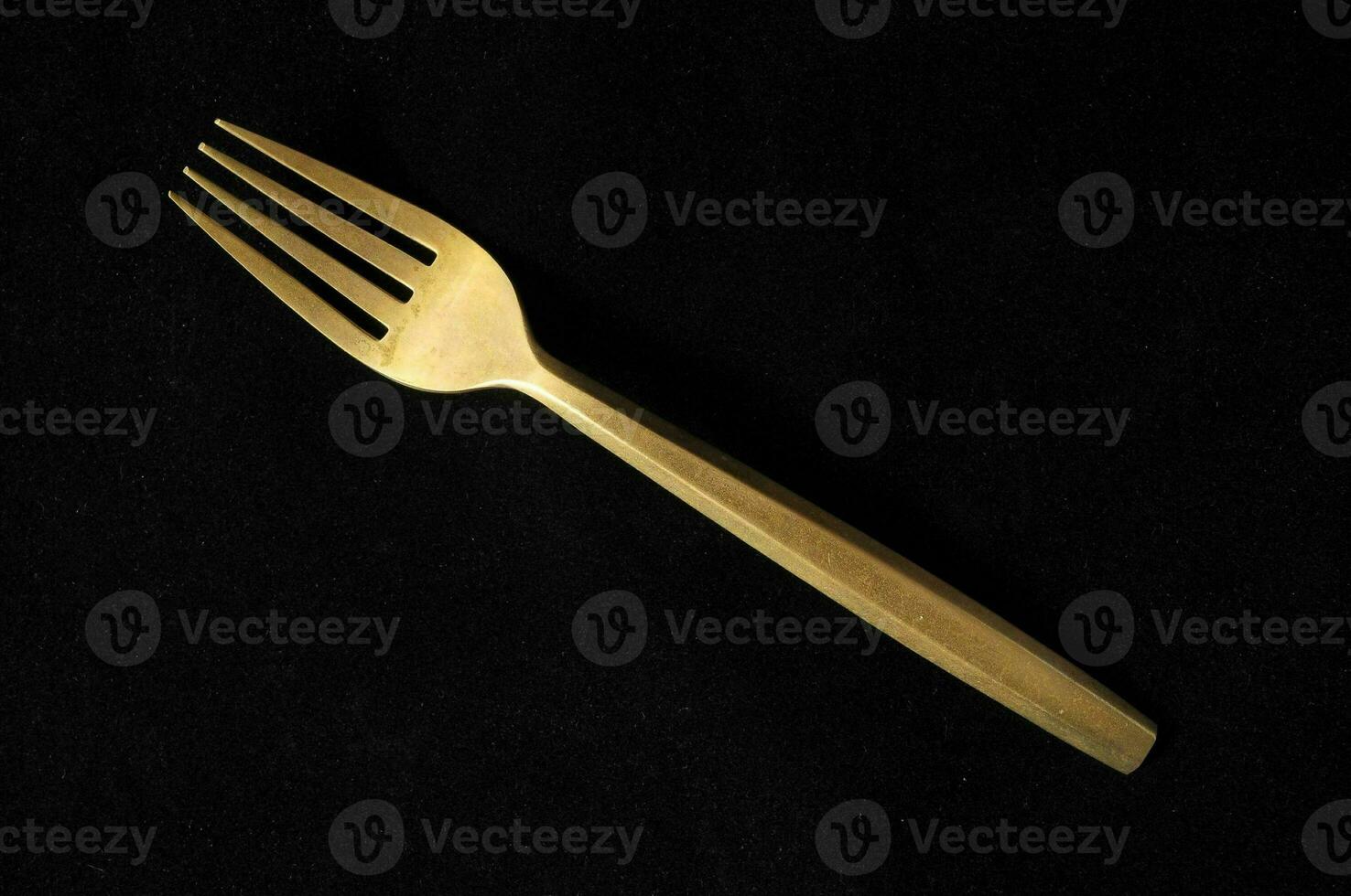 een vork met een goud omgaan met Aan een zwart achtergrond foto
