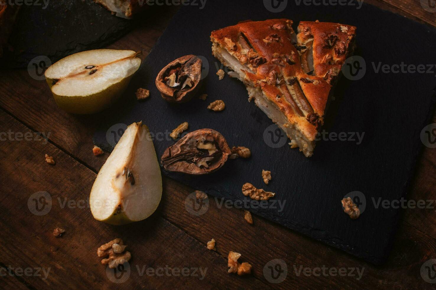 stuk van Peer taart Aan een zwart portie bord Aan een houten tafel foto