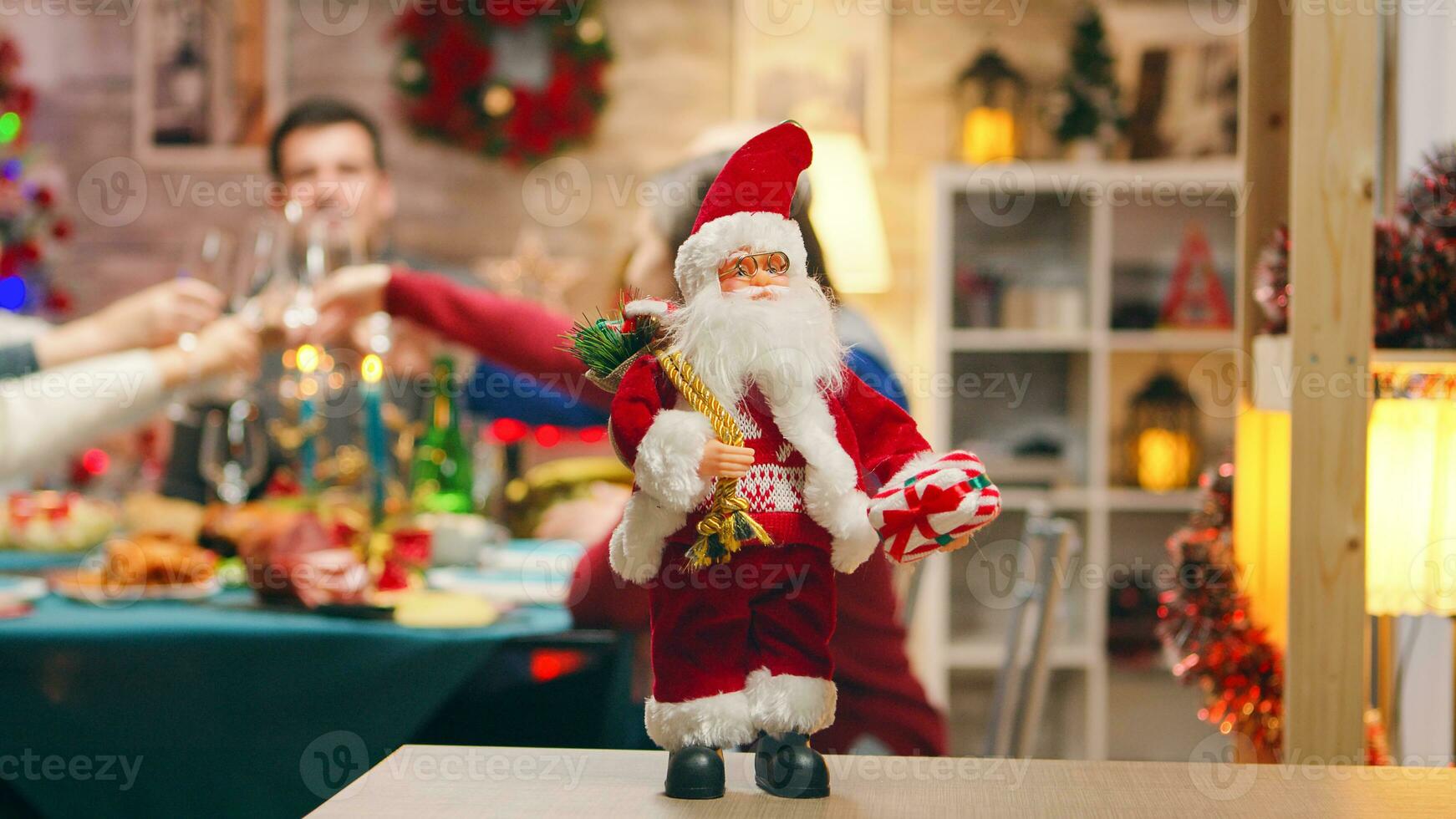 de kerstman claus in focus Aan de tafel met groot familie vieren Kerstmis in de achtergrond. traditioneel feestelijk Kerstmis avondeten in multigenerationeel familie. genieten van Kerstmis maaltijd feest in versierd kamer. groot familie bijeenkomst foto