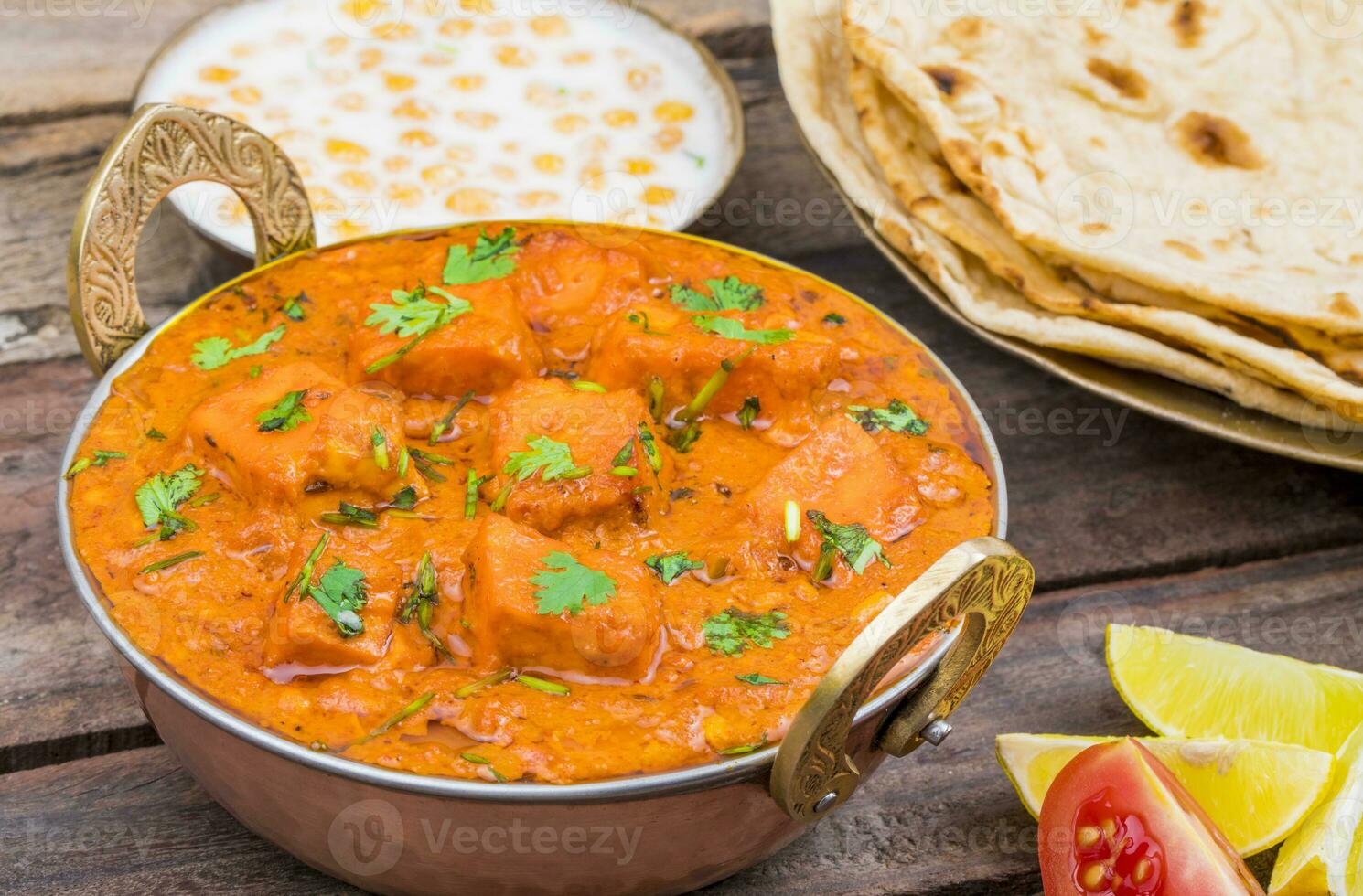 Indisch heerlijk keuken paneer tikka masala met tandoori chapati Aan houten achtergrond foto