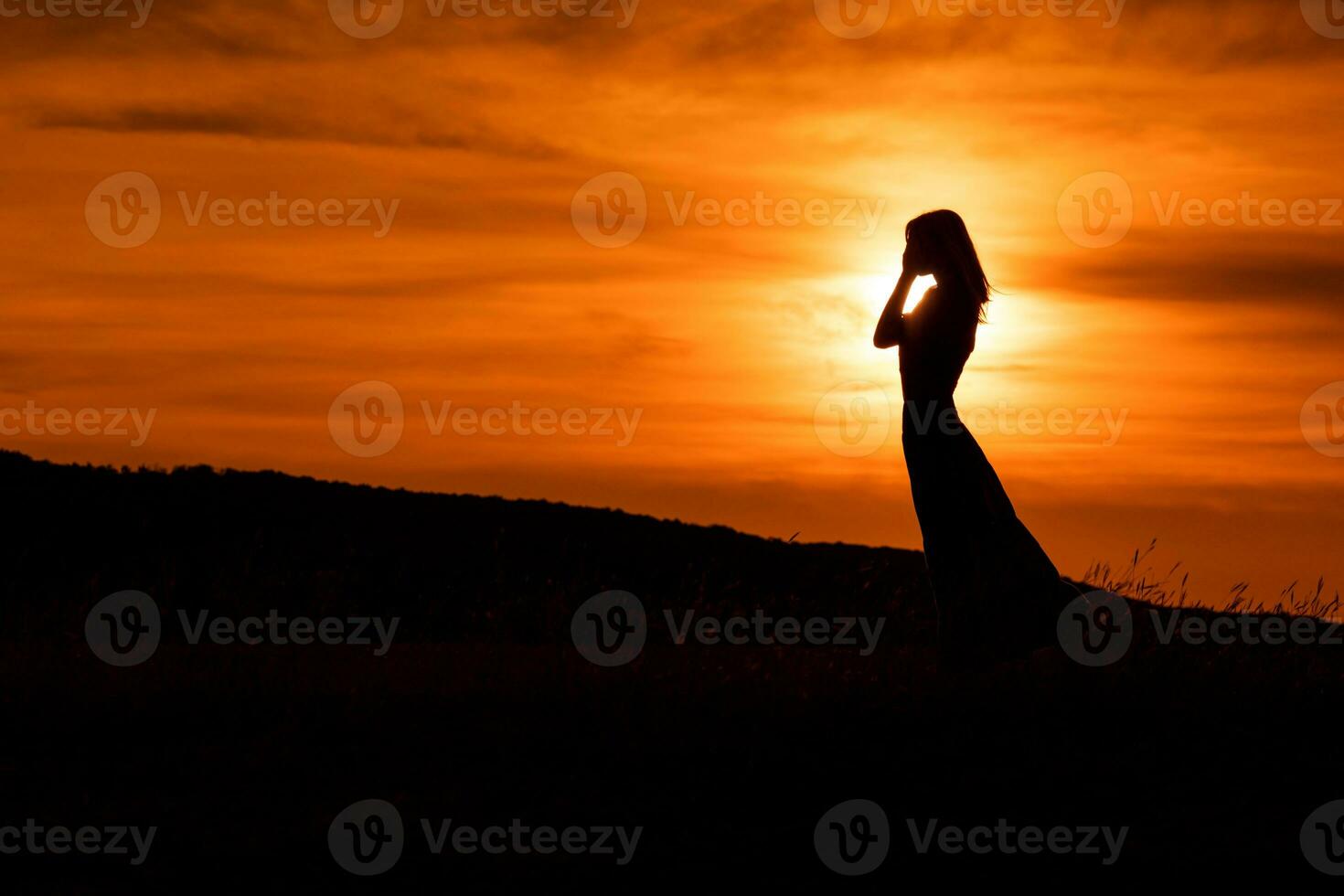 silhouet van een verdrietig vrouw staand Bij de zonsondergang. foto