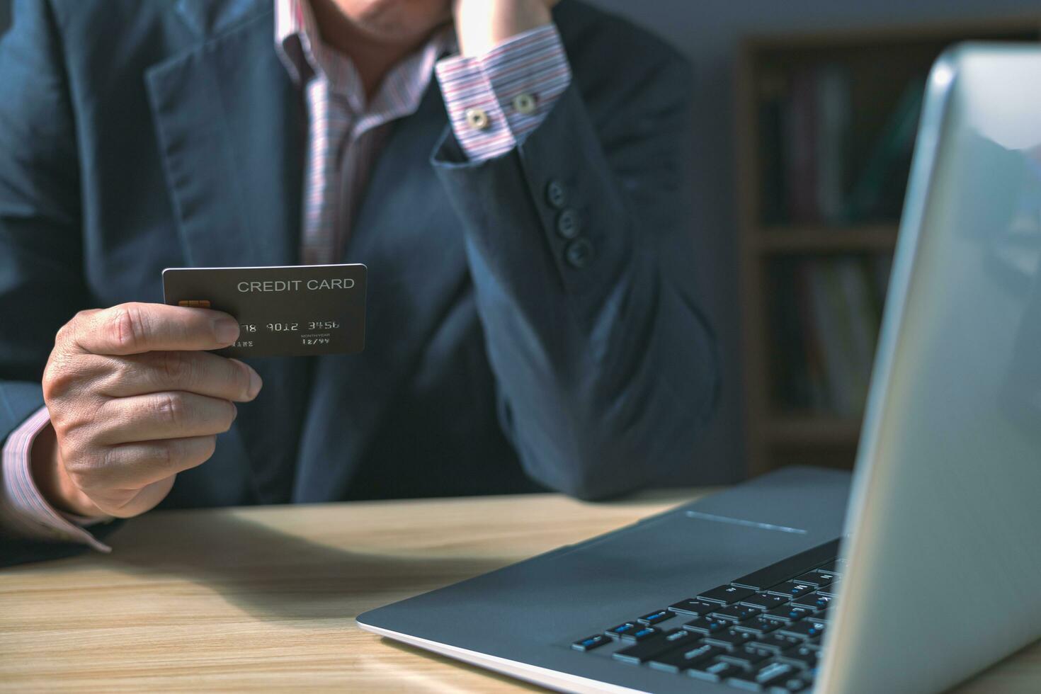 zakenman tonen credit kaart in kantoor, Mens benadrukt met credit kaart schuld, recessie, huishouden schuld, werkloosheid foto