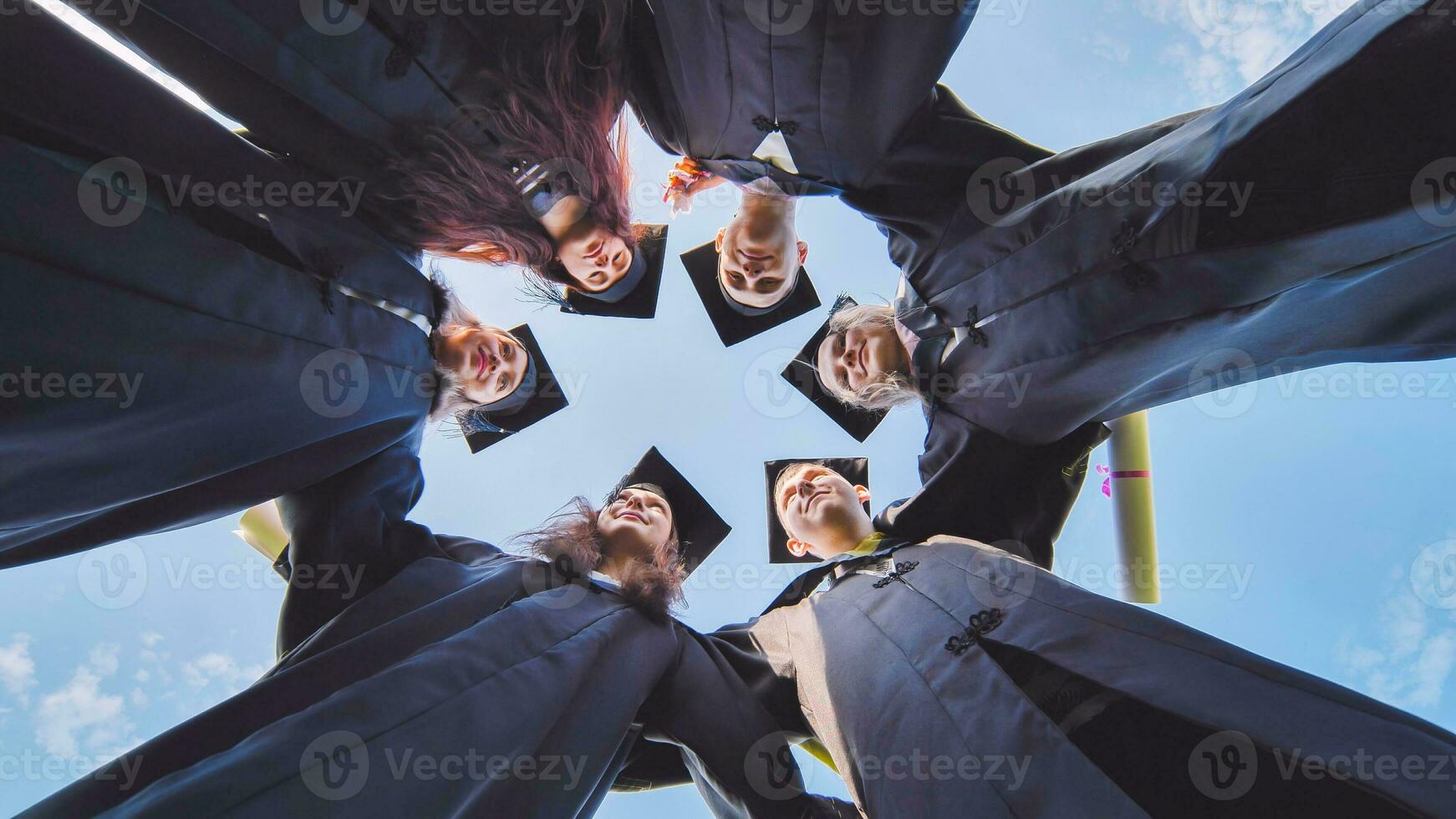 college studenten staan in een cirkel vervelend zwart Jurken. foto