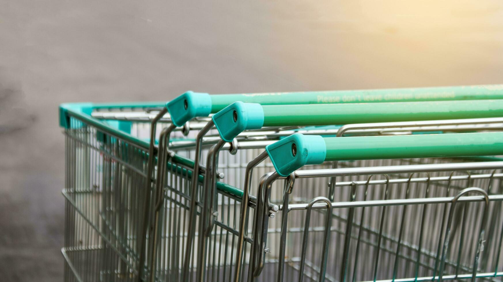 dichtbij omhoog visie van boodschappen doen kar handvatten Aan donker achtergrond foto