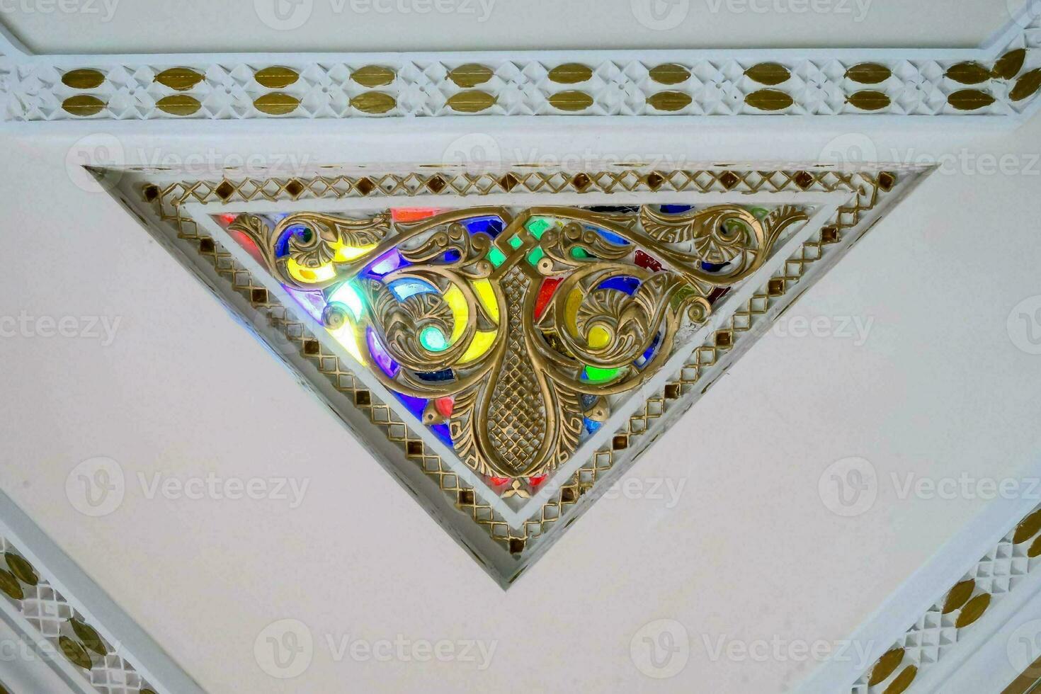 een decoratief driehoek met kleurrijk glas Aan de plafond foto