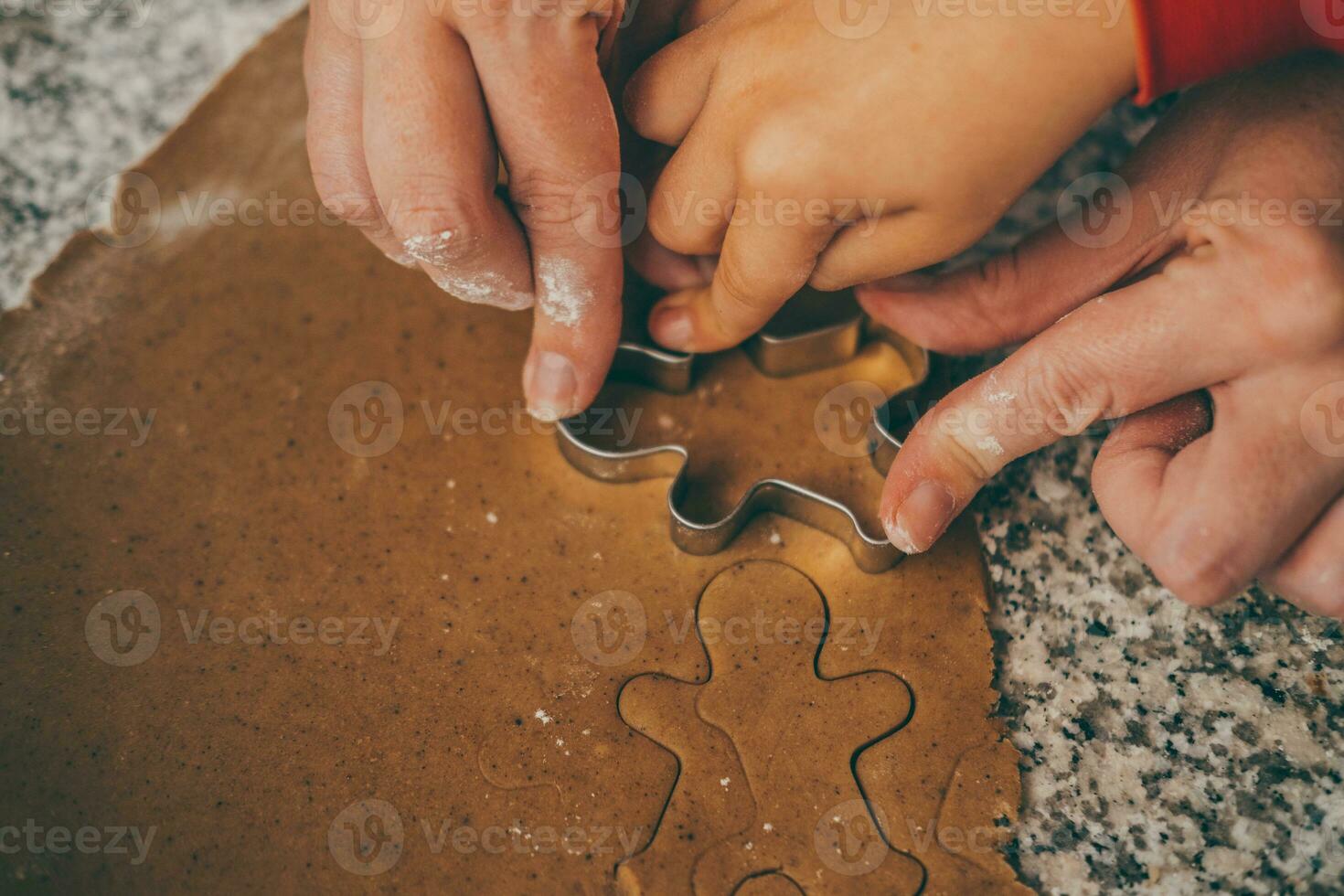 een mam en haar zoon bezighouden in de verrukkelijk taak van voorbereidingen treffen Kerstmis peperkoek foto