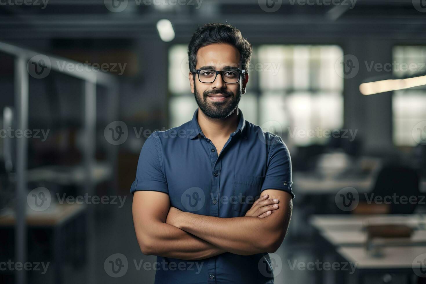 ai gegenereerd een jong Indisch mannetje ontwerper, ingenieur, architect wie is vervelend bril en een blauw overhemd glimlachen staand in de kantoor en op zoek Bij de camera foto