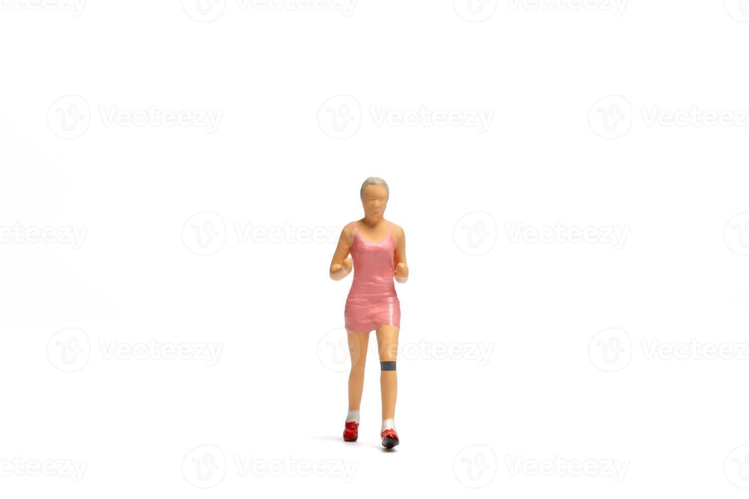 miniatuurmensen, vrouw in fitnesskleding die op witte achtergrond loopt foto