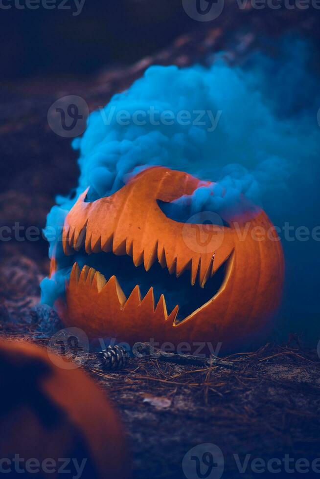 blauw rook komt eraan van gesneden pompoen gezicht foto