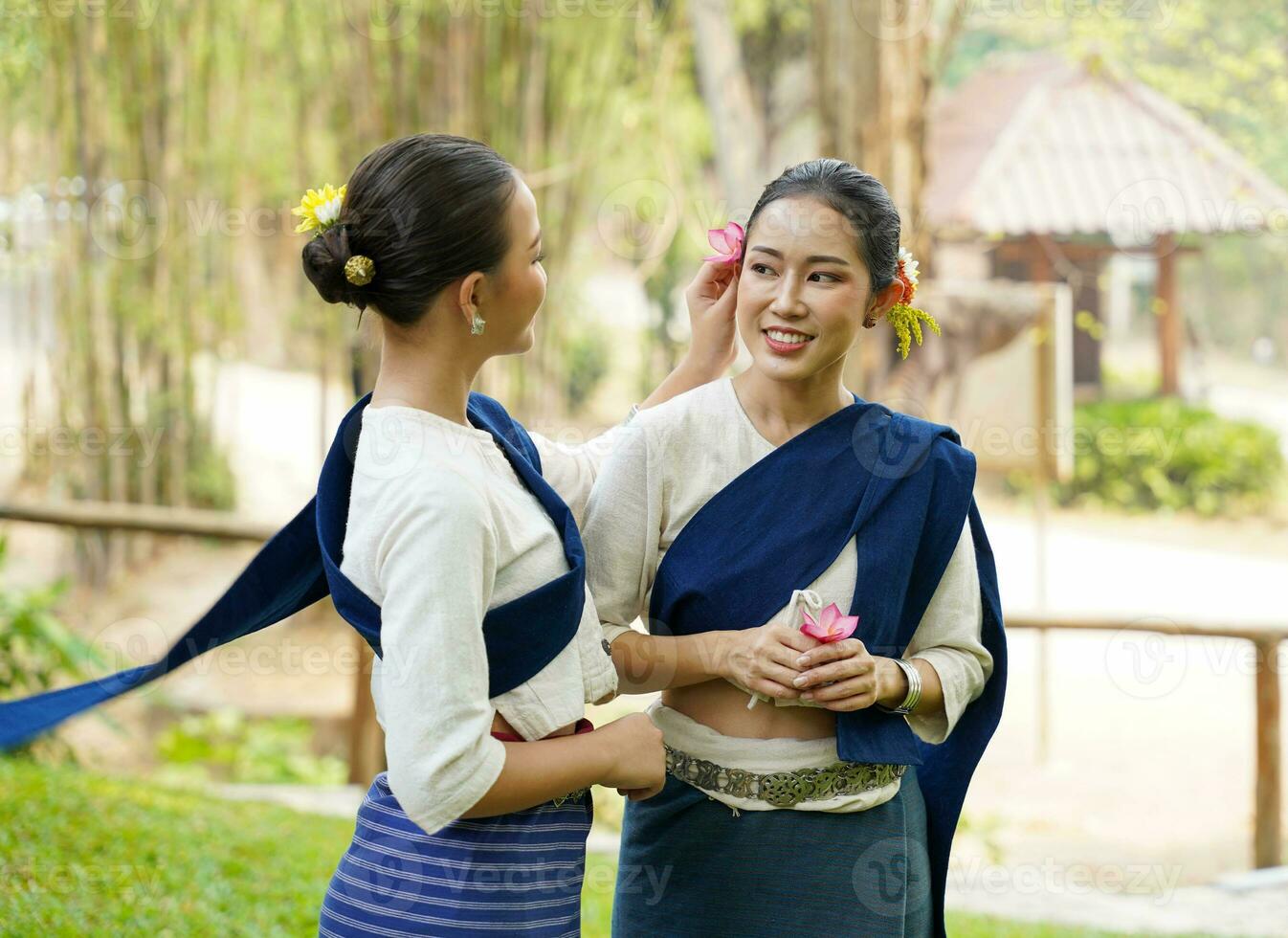 detailopname een mooi Thais jong dame ware Thais noordelijk traditioneel jurk chatten en plagen elk andere Aan wazig achtergrond. foto
