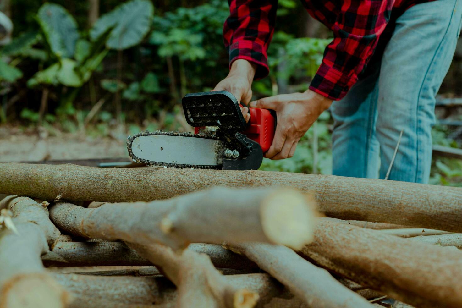 een boer is gebruik makend van een keten zag naar besnoeiing brandhout. foto