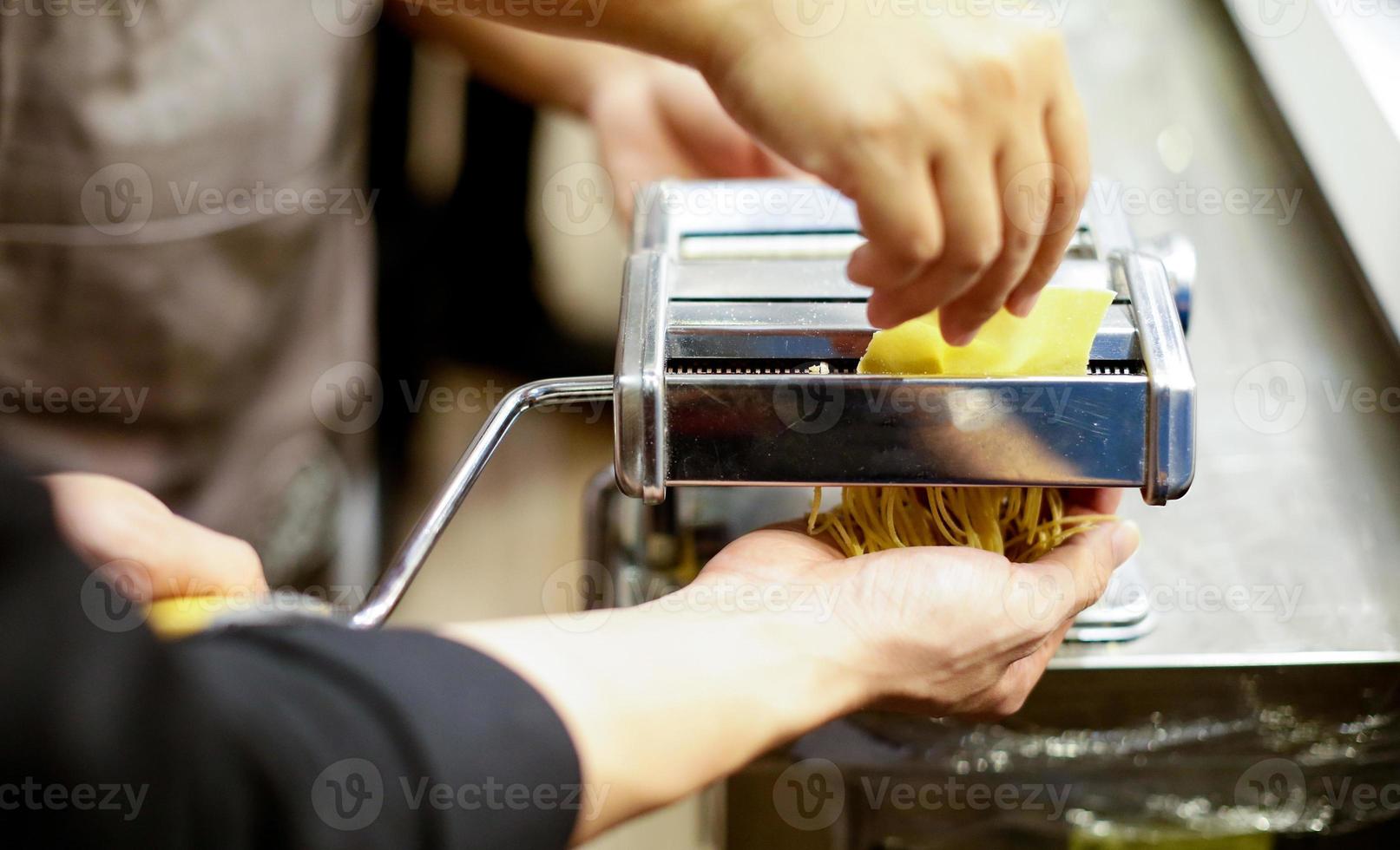 chef-kok maakt pasta met een machine, zelfgemaakte verse pasta foto