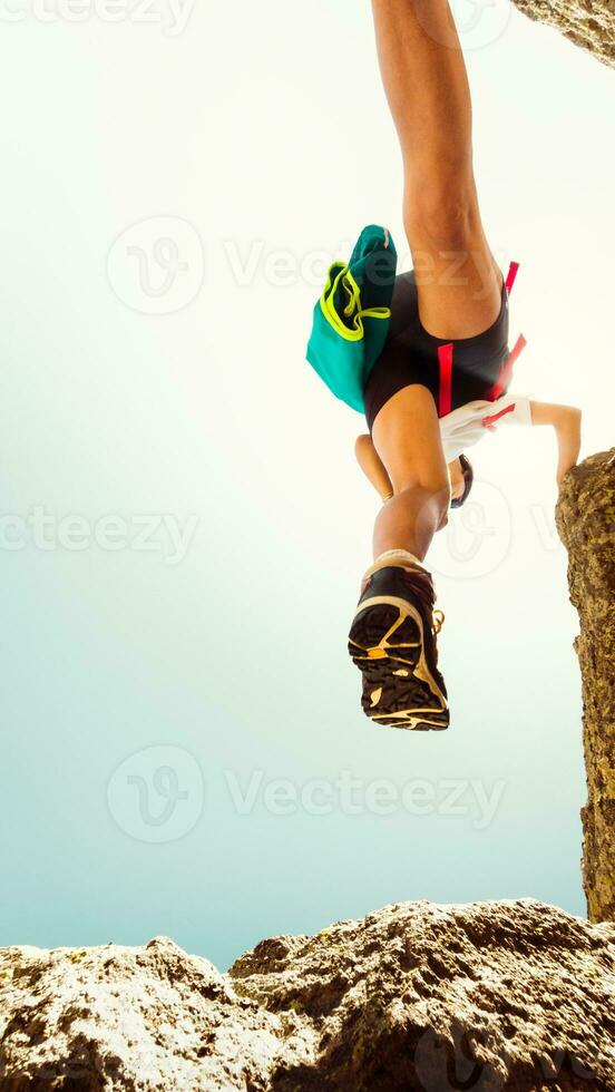 laag visie vrouw lichaam stap voeten in lucht Aan wandelen over- rotsen buitenshuis alleen in heet zonnig dag buitenshuis. beweging vervagen filter. schoen grip en schoenen Aan beklimming concept foto