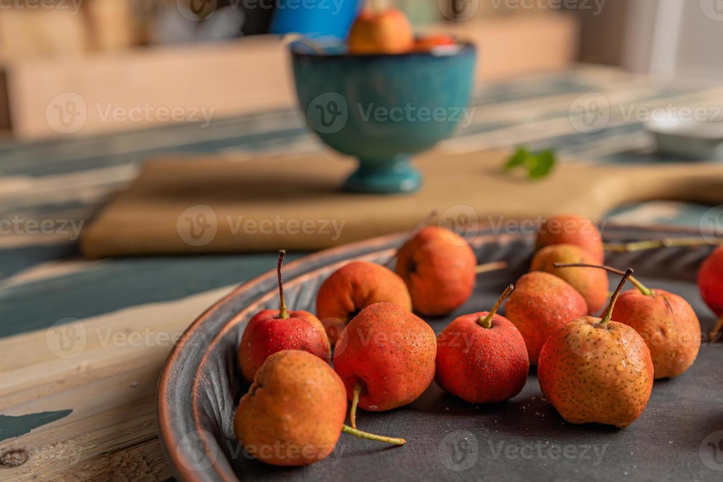 de rode meidoorn in de kom wordt op de houten tafel geplaatst foto