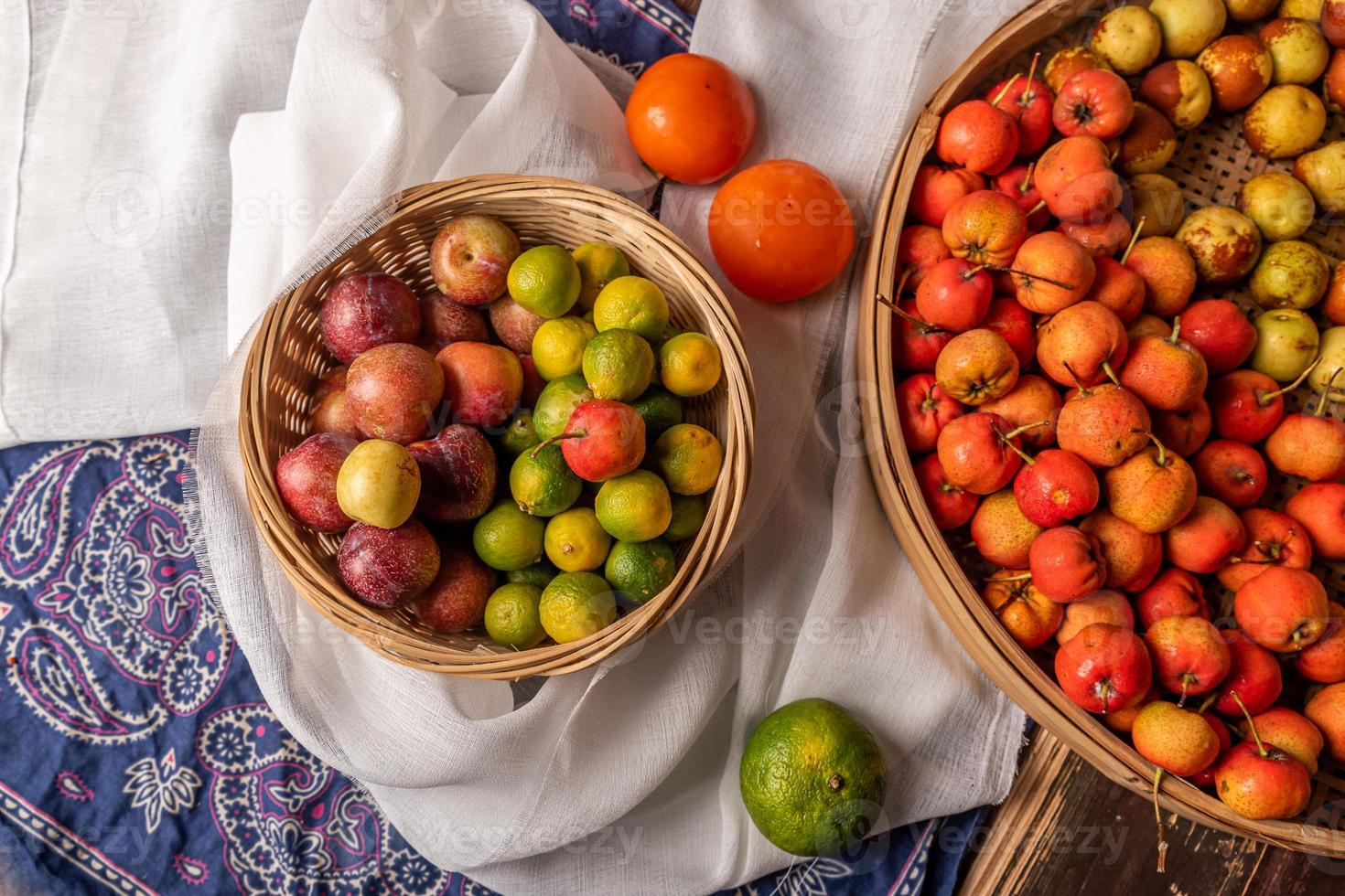 veel kleuren en soorten fruit liggen op het bord of verspreid op de houten tafel foto