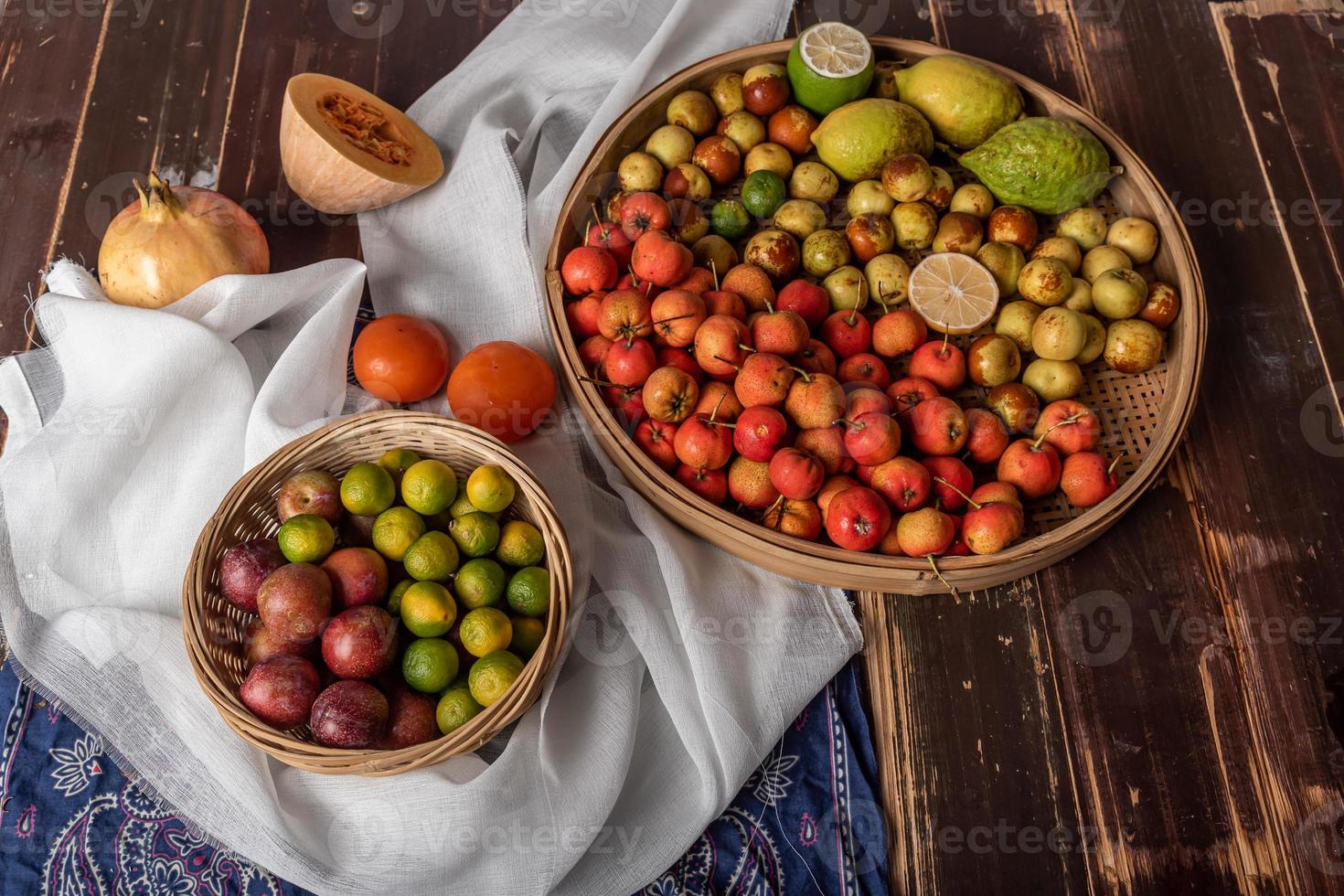 veel kleuren en soorten fruit liggen op het bord of verspreid op de houten tafel foto