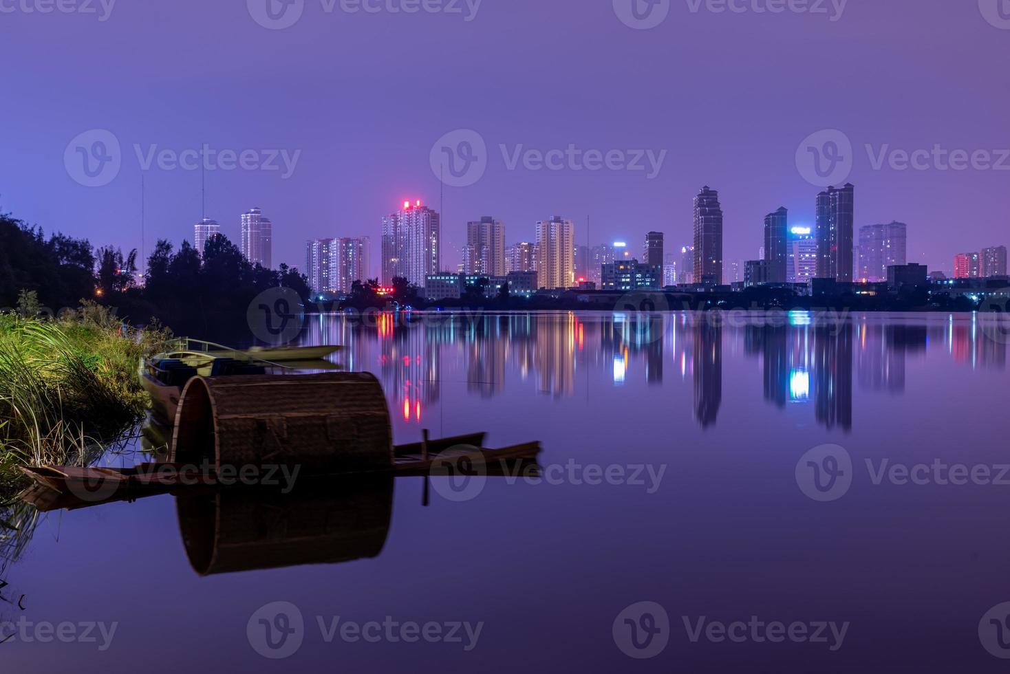 een stad die 's nachts wordt weerspiegeld door het meer foto