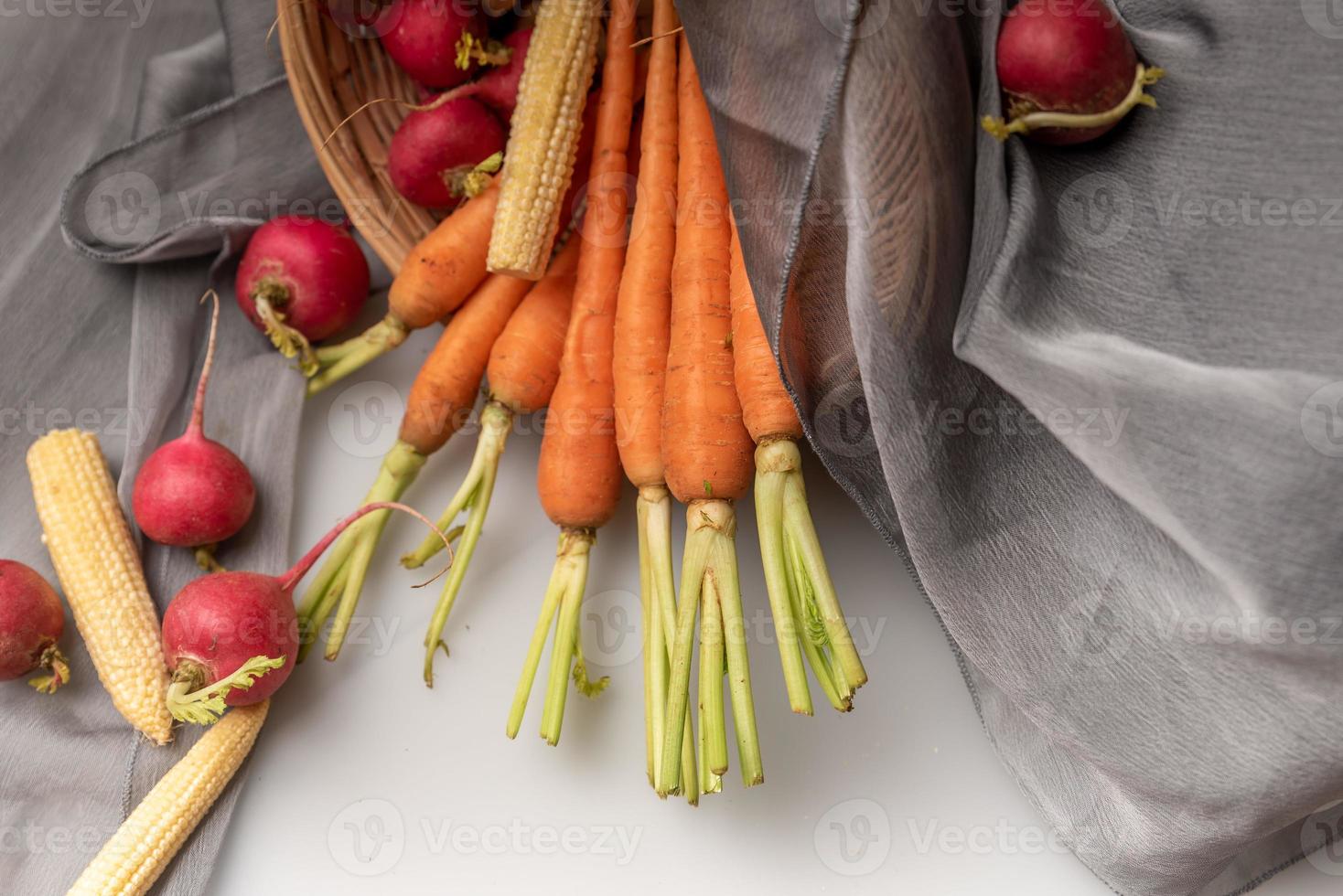 de rode en oranje radijsjes liggen op de witte doek foto