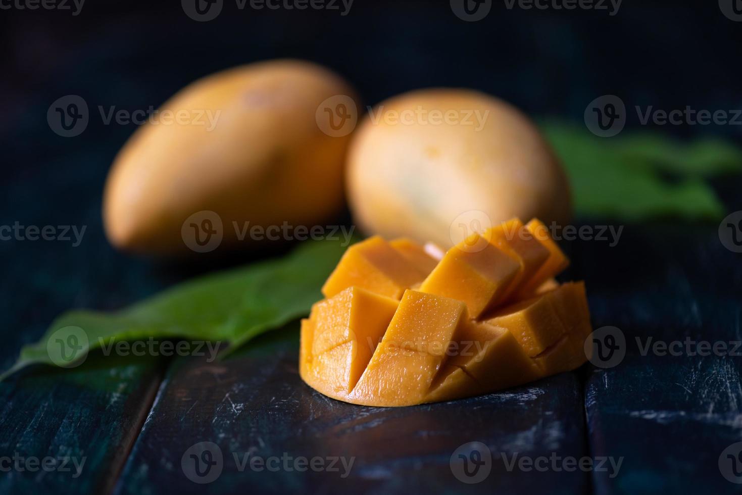 gesneden en intacte mango's op de donkere achtergrond foto
