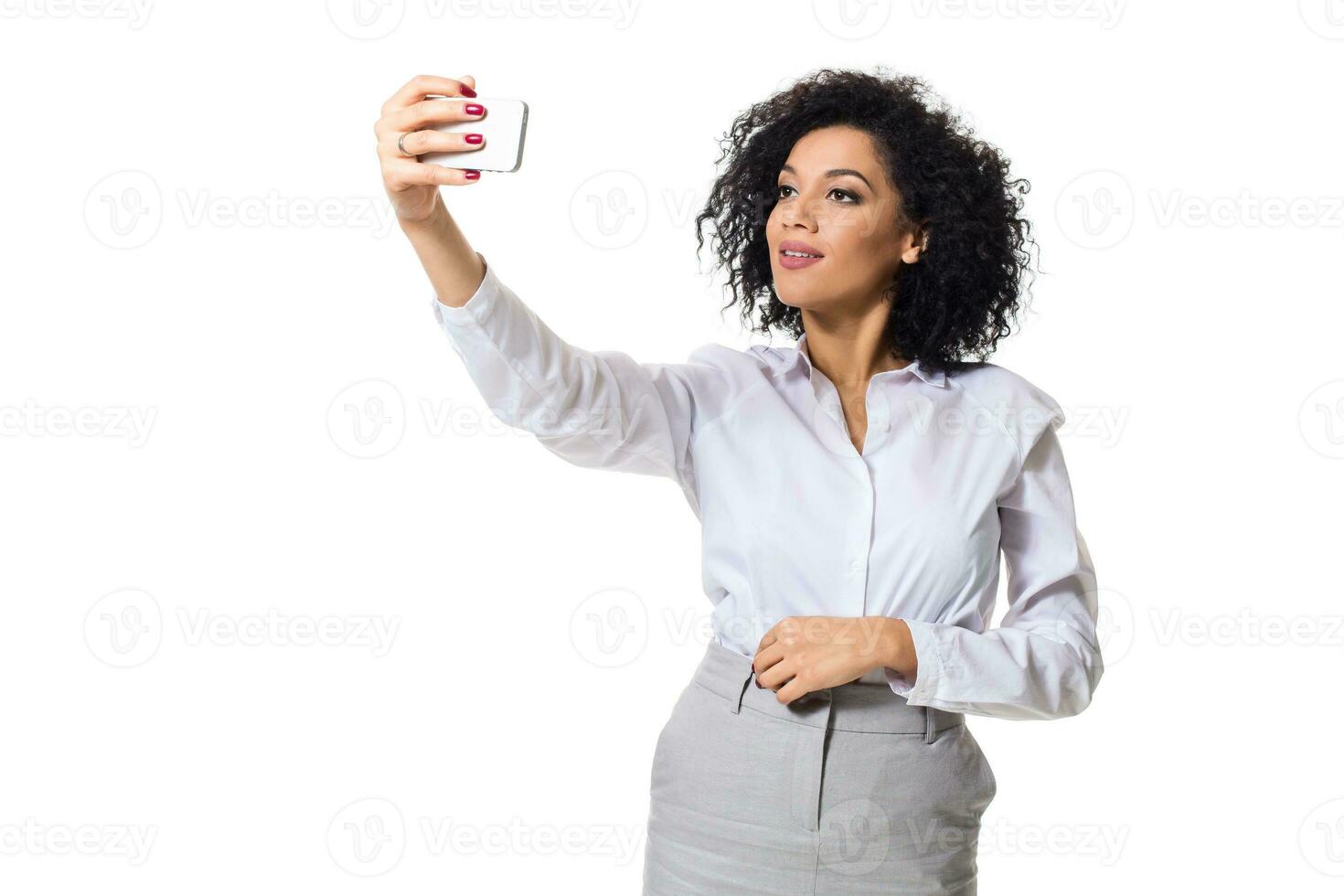 mooi brunette vrouw in klassiek wit overhemd en rok maken selfie Aan de telefoon. foto