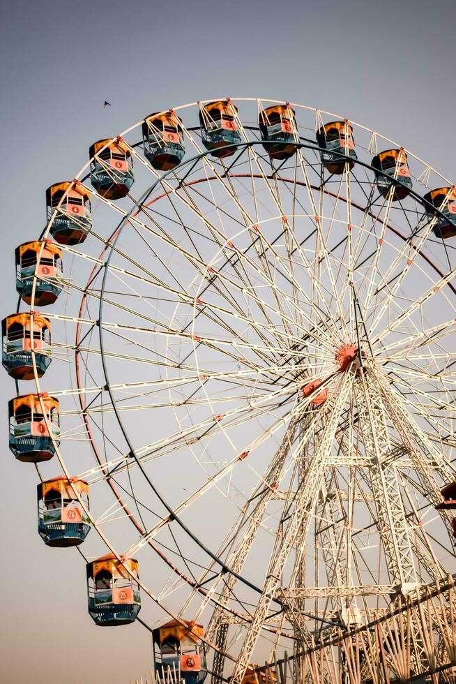 nieuw Delhi, Indië - oktober 30 2023 - detailopname van veelkleurig reusachtig wiel gedurende dussehra mela in Delhi, Indië. bodem visie van reusachtig wiel schommel. reuzenrad met kleurrijk hutten gedurende dag tijd. foto