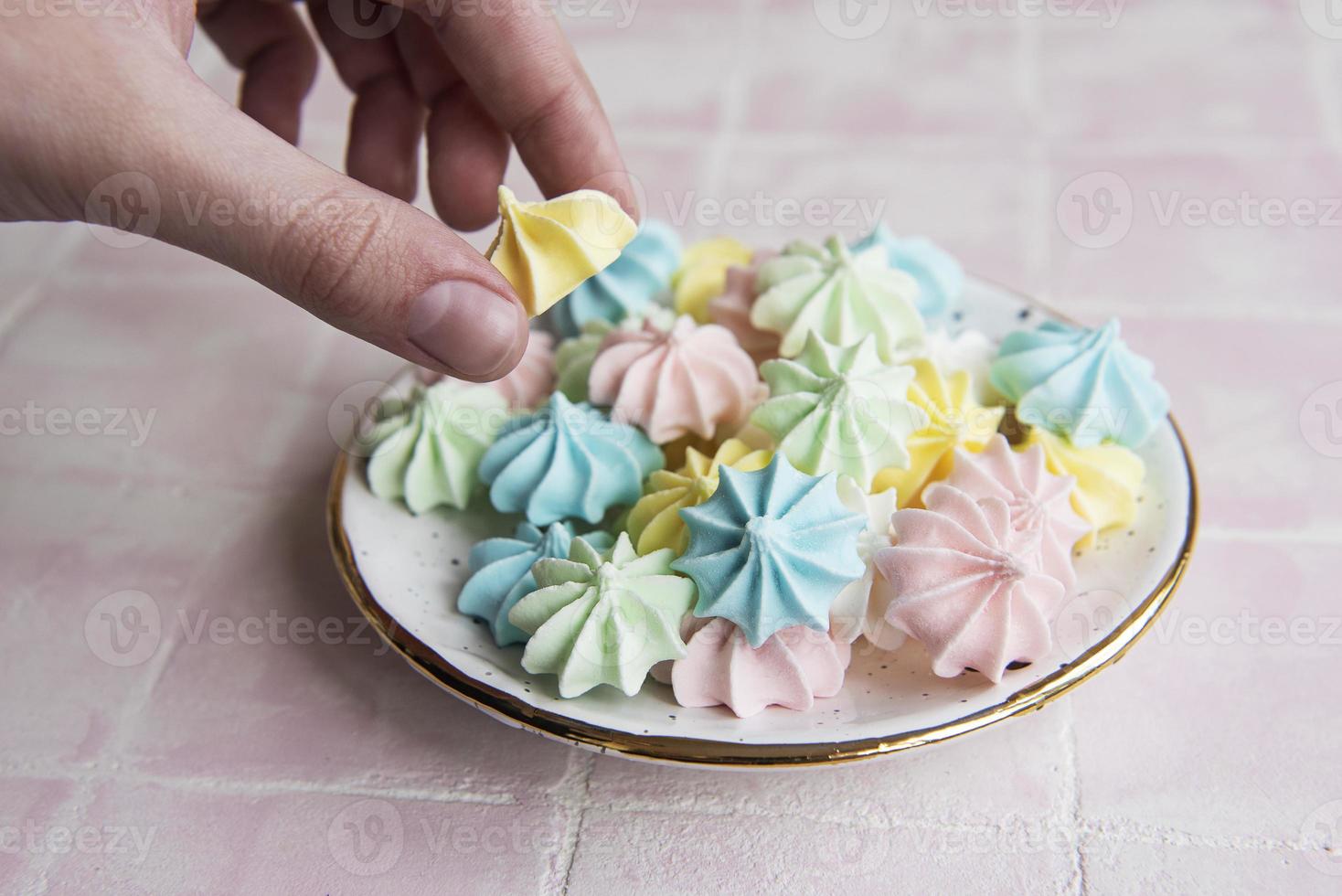 kleine kleurrijke schuimgebakjes in de keramische plaat foto