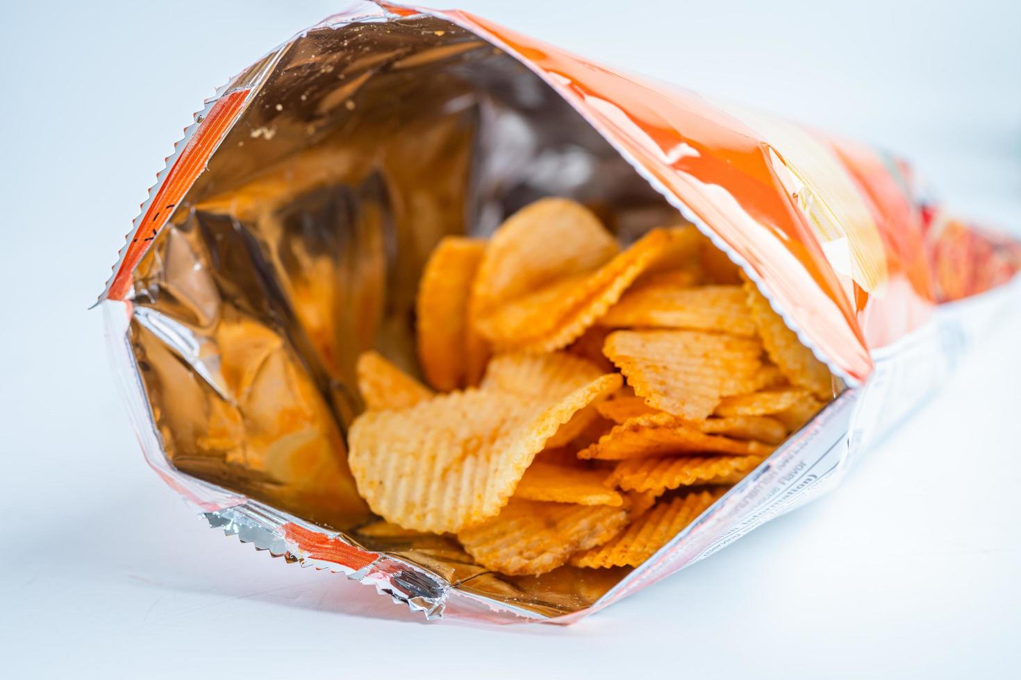 chips, heerlijke bbq-kruiden pittig voor crips, dunne plak gefrituurde snack fastfood in open zak foto