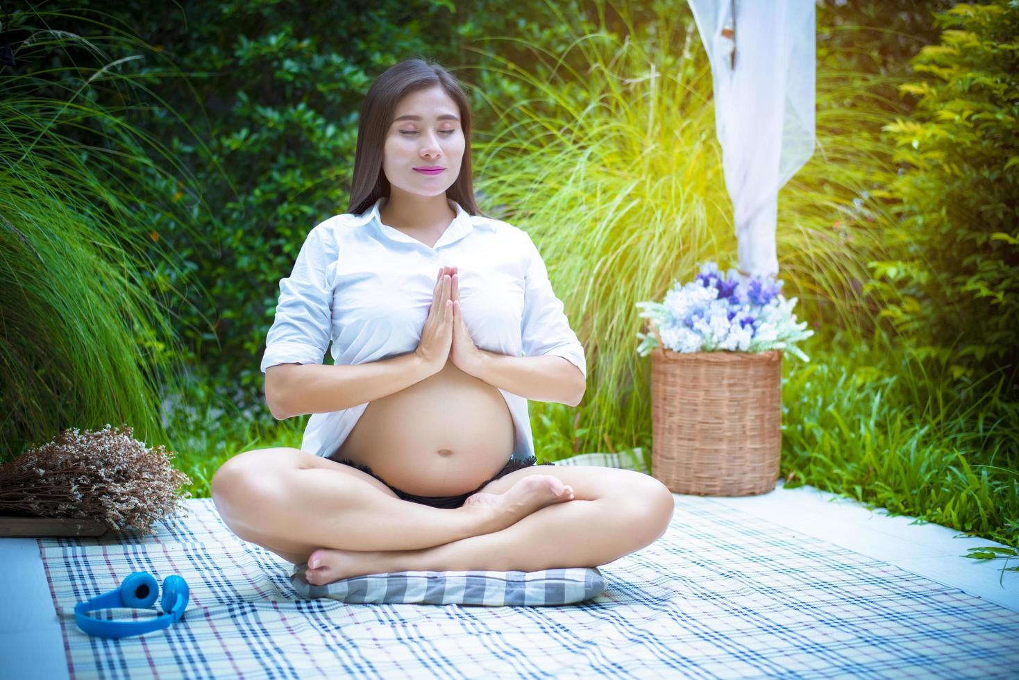 zwangere vrouw die yoga doet in de buitenlucht foto