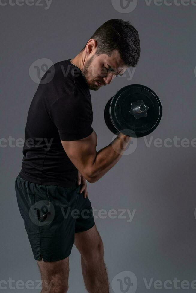 gefocust jong Mens het uitvoeren van halter biceps krullen foto