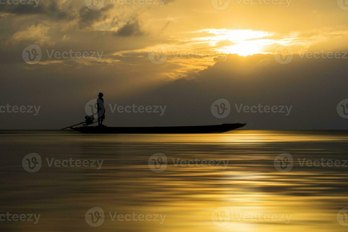 silhouetten van visser Bij de meer met zonsondergang, Thailand. foto