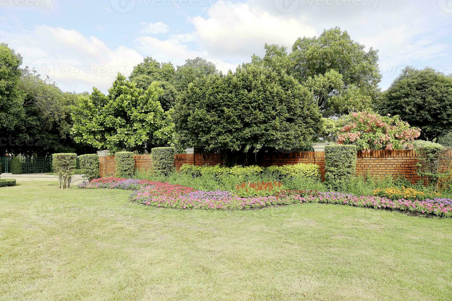 toneel- visie van een mooi bloem stijl landschap tuin met een groen gemaaid gazon en kleurrijk bloem bed met selectief focus foto