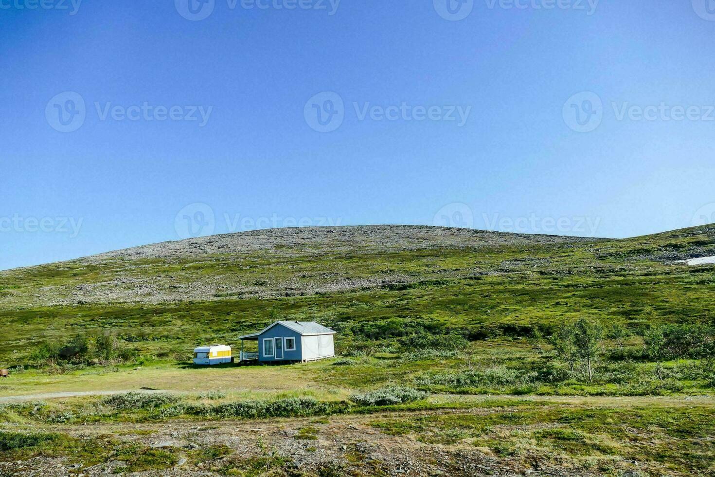 een klein cabine in de midden- van een met gras begroeid veld- foto