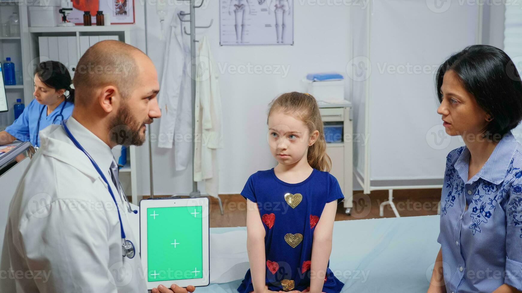 dokter pratend met kind moeder en Holding een groen scherm tablet.gezondheidszorg specialist met chroma sleutel notitieboekje geïsoleerd mockup vervanging scherm. gemakkelijk keying geneeskunde medisch verwant thema. foto