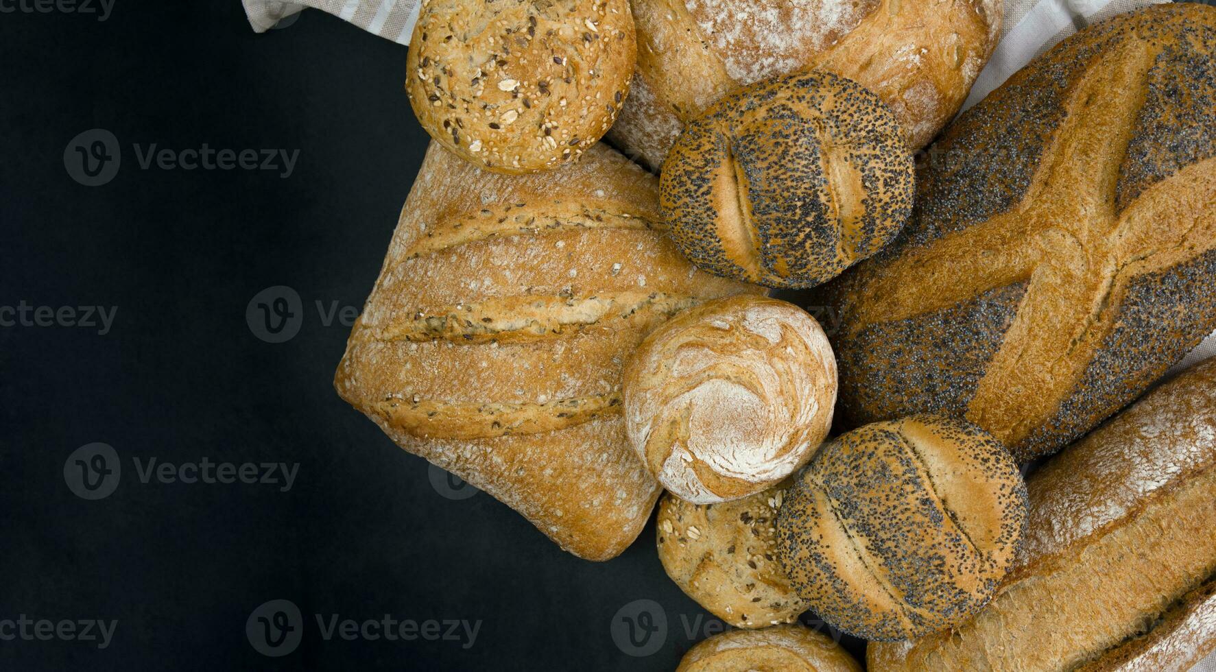 vers gebakken brood en broodjes Aan een zwart achtergrond. kopiëren ruimte. foto