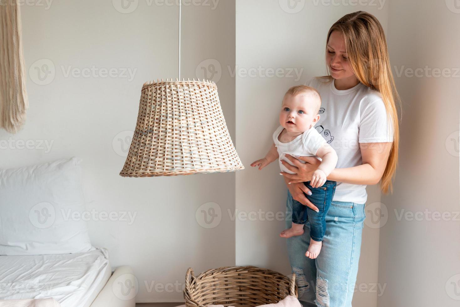 mooie vrouw met een pasgeboren baby in haar armen in de slaapkamer foto